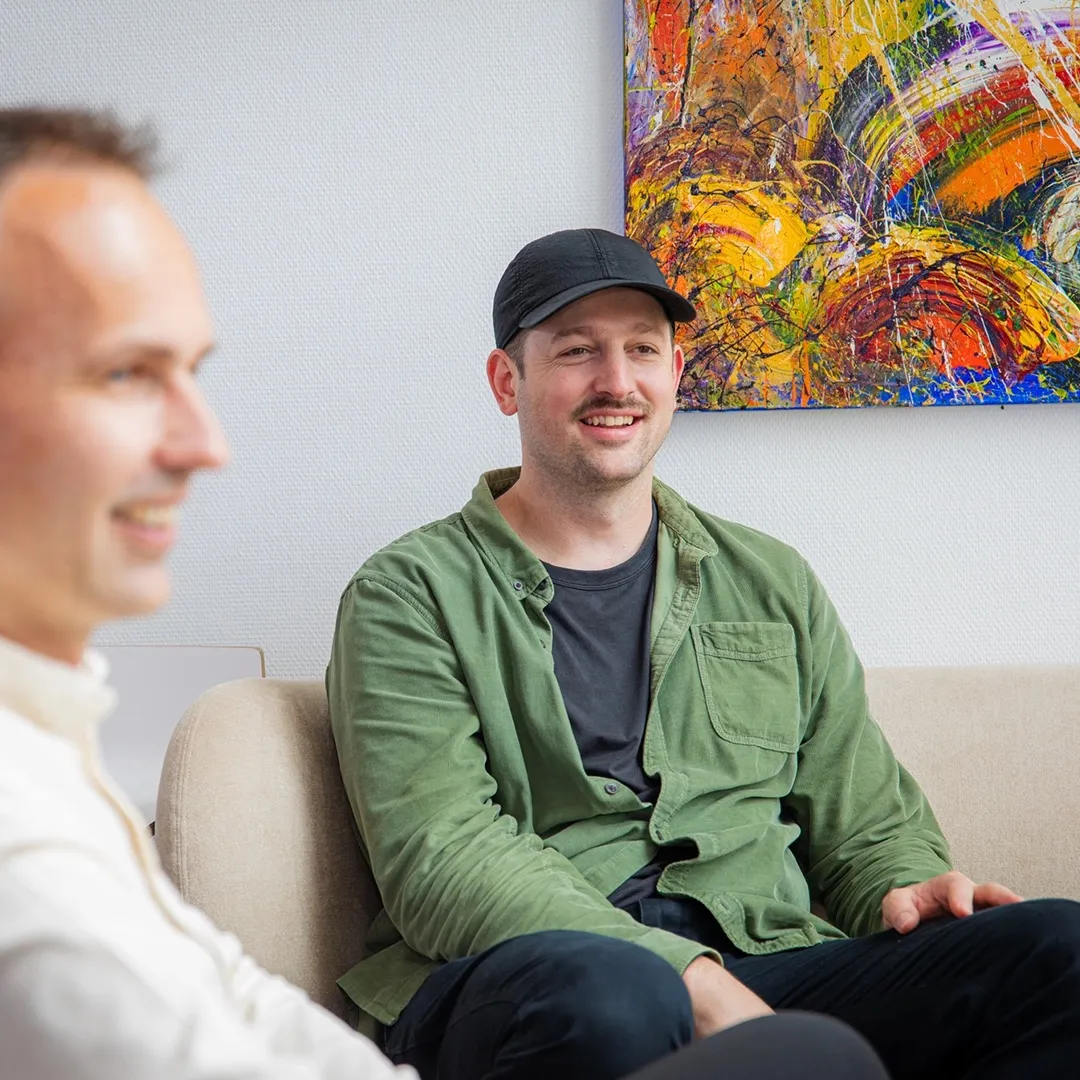 A colleague in a cap smiling in the lounge