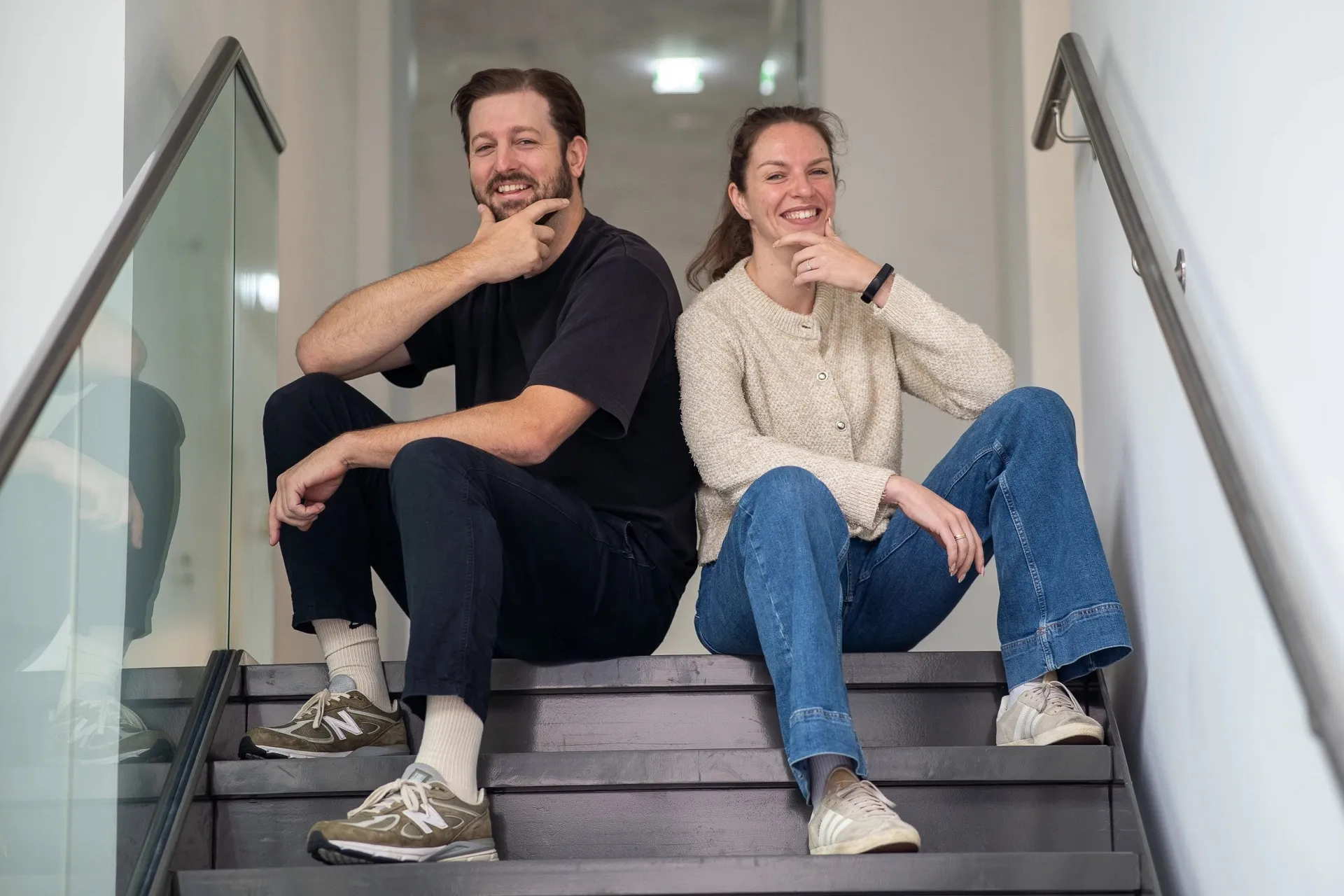 Two colleagues sitting on the office stairs